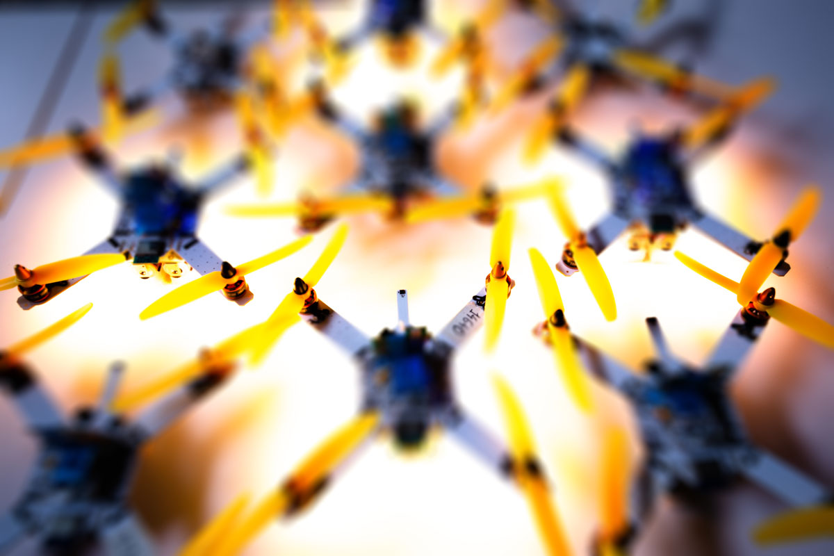 Artistic macro of lit-up drones with yellow propellers and warm glow