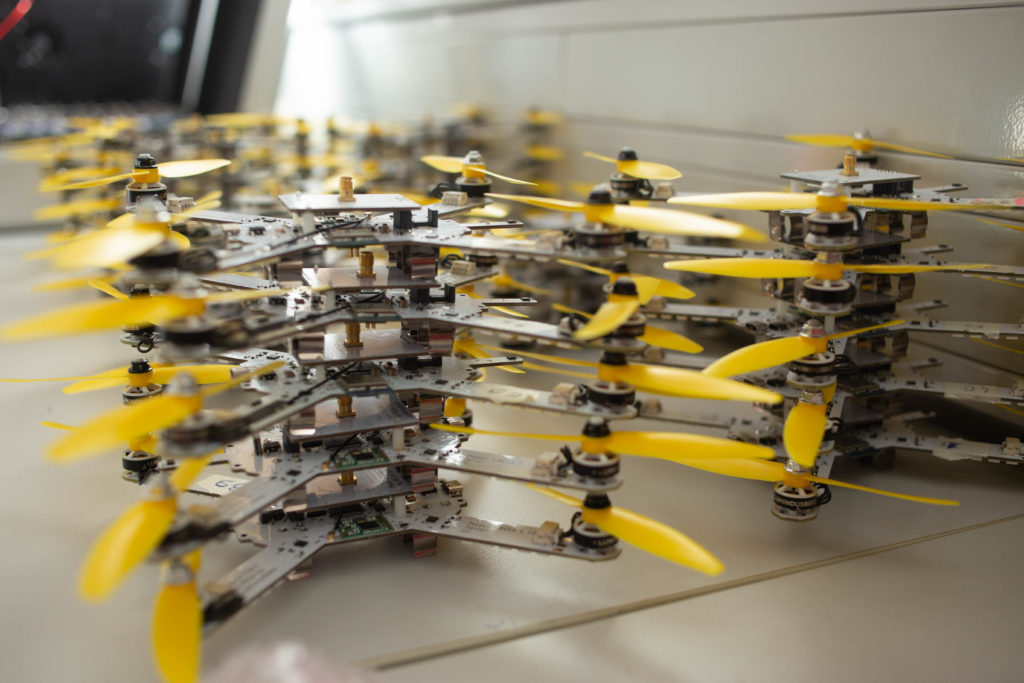 Many drones stacked closely together on a table ready for deployment