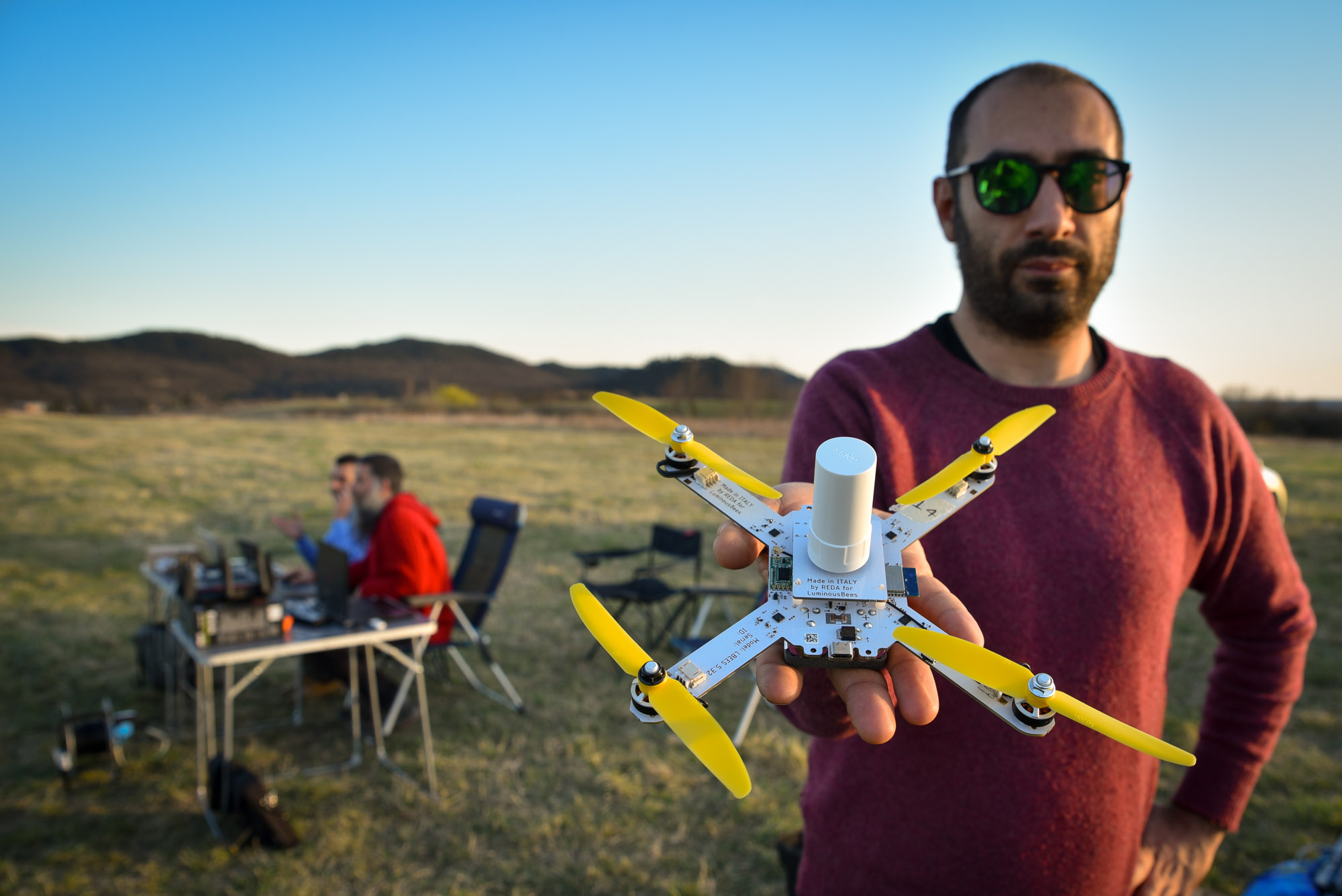 Giorgio Rinolfi holding a LuminousBee drone with the team in the background